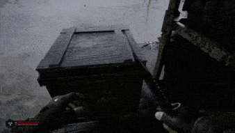a person is holding a gun next to a wooden box .