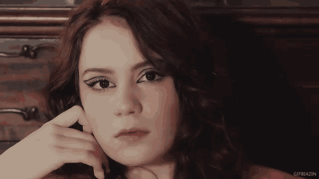a close up of a woman 's face with gifbiazin in the bottom right corner