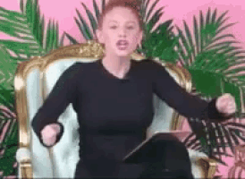 a woman in a black dress is sitting in a chair holding a tablet .