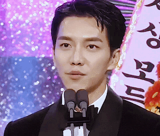a man in a tuxedo speaking into a microphone