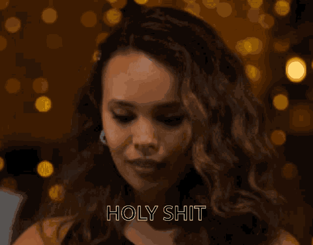 a close up of a woman 's face with the words holy shit above her