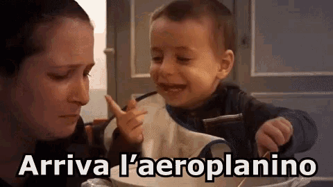 a woman is feeding a baby with a spoon and the baby is crying and says arriva l ' aeroplanino .