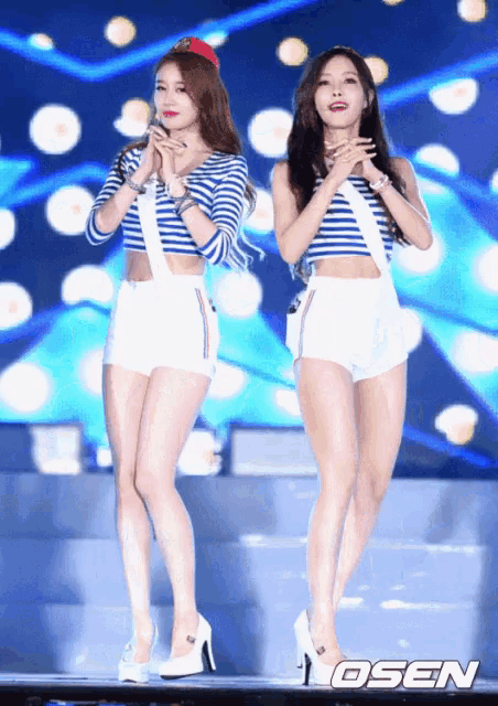 two women are standing on a stage with osen written on the bottom