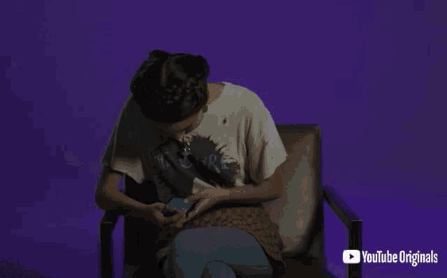a woman sits in a chair with a youtube originals logo on the bottom right