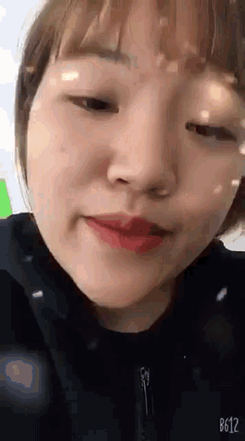 a close up of a woman 's face with the number b612 on the bottom right corner