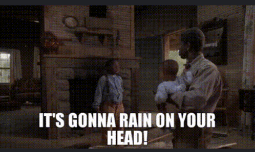 a man holding a baby says it 's gonna rain on your head in a living room