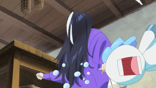 a woman in a purple shirt is standing next to a cartoon character with bubbles coming out of its mouth