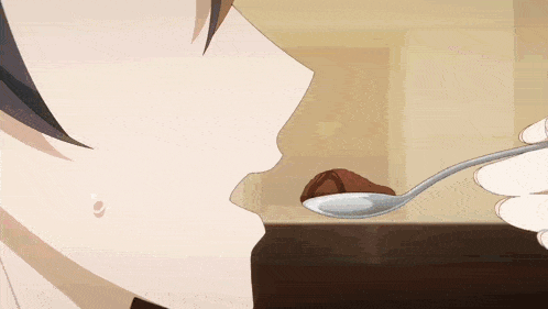 a person is holding a spoon in front of their mouth