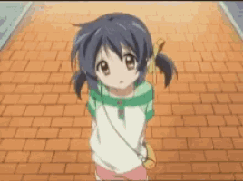 a little girl with pigtails is standing on a brick walkway