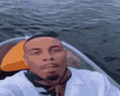 a man in a white shirt and tie is taking a selfie on a boat