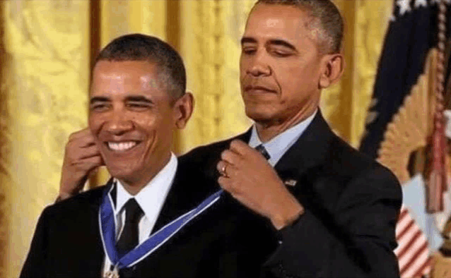 barack obama is receiving a medal from another man .