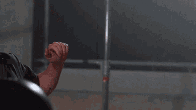 a man with a beard wearing a black shirt is standing in a dark room