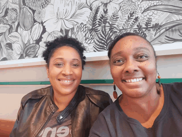 two women are posing for a picture with one wearing a t-shirt that says ' 19 '