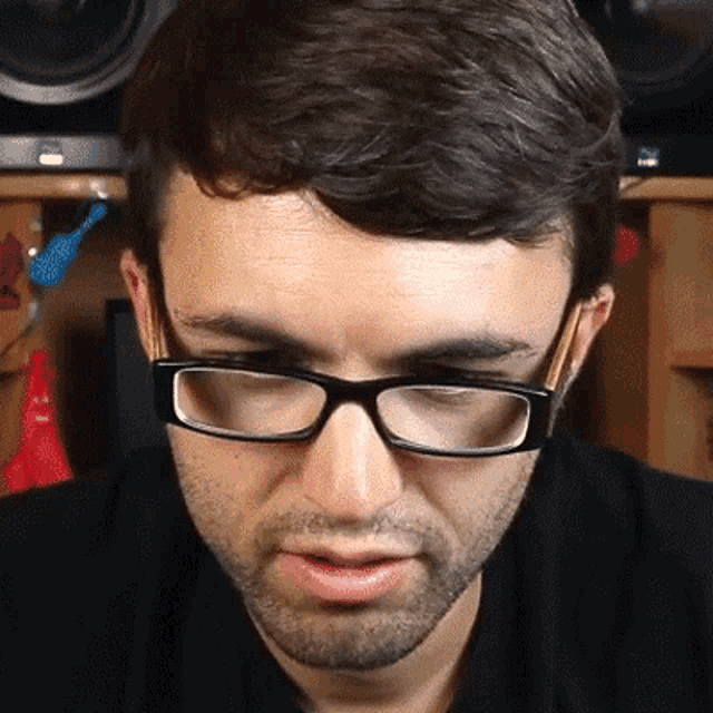 a close up of a man wearing glasses with a beard