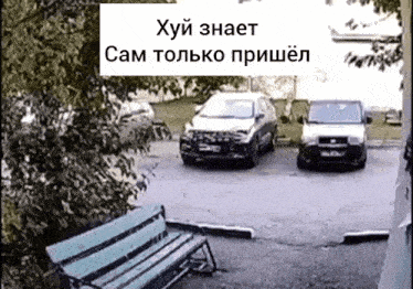 two cars are parked in a parking lot with a sign in russian that says " хуй знает "