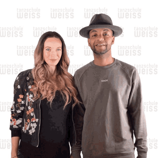 a man and woman are posing for a picture in front of a tanzschule weiss background