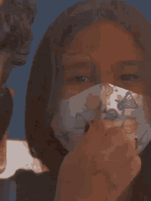 a close up of a woman wearing a face mask with a red lip .