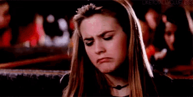 a woman is making a funny face while sitting in a crowded room .