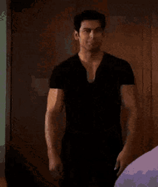 a shirtless man is standing in front of a door with his arms over his head .