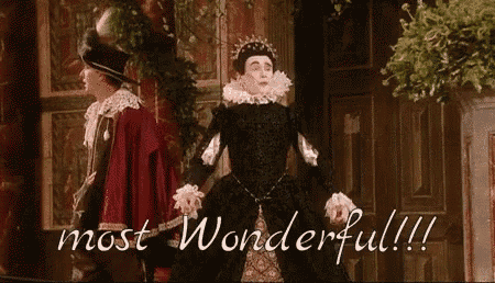 a woman in a black dress is standing next to a man in a red coat and a sign that says most wonderful !