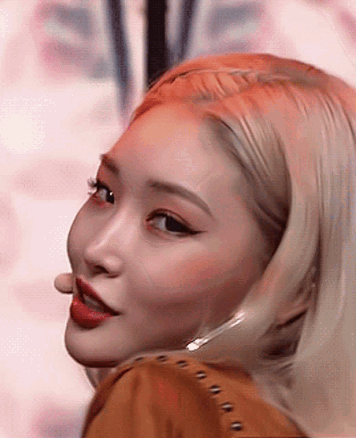 a close up of a woman with blonde hair and red lipstick .
