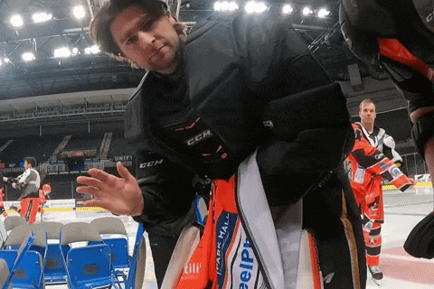 a man wearing a jacket that says ccm is standing on a ice rink