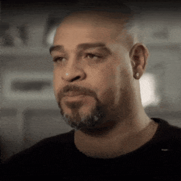 a man with a beard is wearing a black shirt