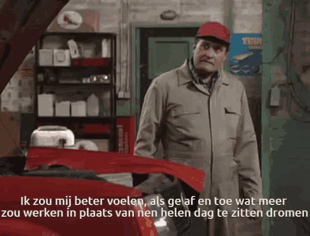 a man is standing in front of a red car with the hood open and says ik zou mij beter voelen