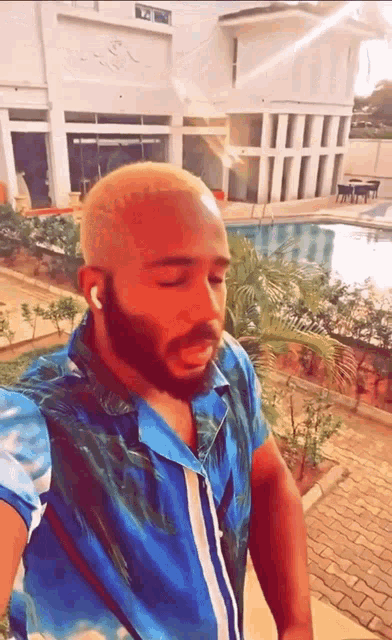 a man in a blue shirt is standing in front of a building that says ' a ' on it