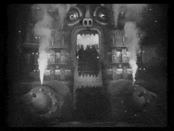 a black and white photo of people walking into a building with smoke coming out of it