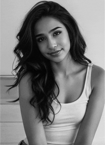 a woman in a white tank top smiles for the camera