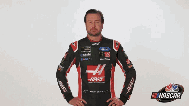 a man in a haas shirt is pointing