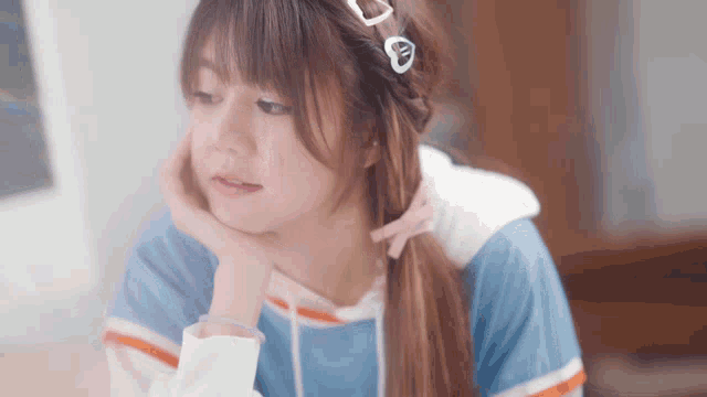 a girl with a ponytail has a heart shaped headband on her hair