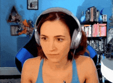 a woman wearing headphones in front of a bookshelf