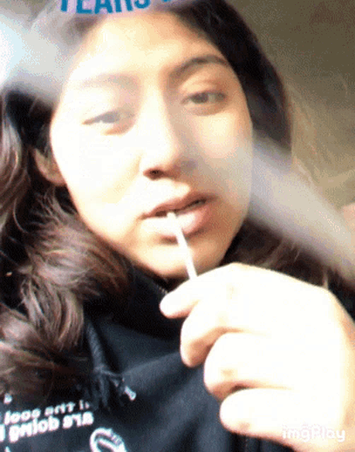 a woman smoking a cigarette with a shirt that says jeep