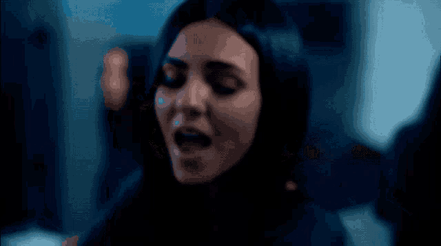 a woman in a dark room with her eyes closed
