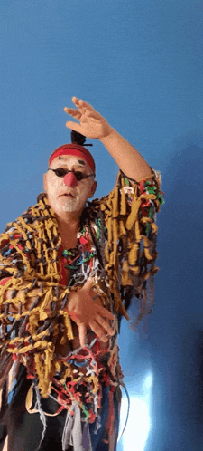 a man in a clown costume with a red nose and sunglasses