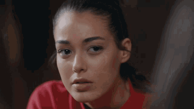 a close up of a woman 's face with a red shirt on