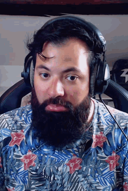 a man with a beard wearing headphones and a shirt with flowers