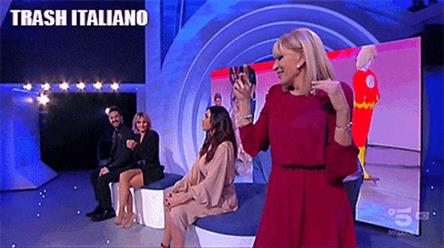 a woman in a red dress stands in front of a screen that says trash italiano on it