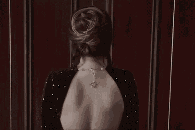 the back of a woman wearing a necklace with a star pendant