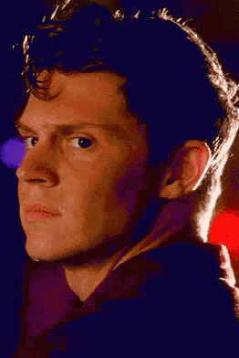 a close up of a man 's face in a dark room