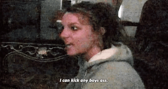 a woman in a gray hoodie is talking and says `` i can kick any boys ass '' .