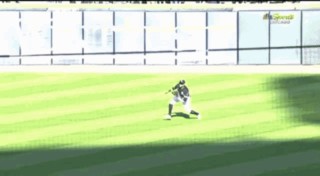 a baseball player is catching a ball on a field that says nbc sports chicago on the fence