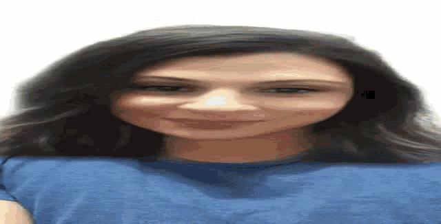 a woman in a blue shirt is smiling and looking down .
