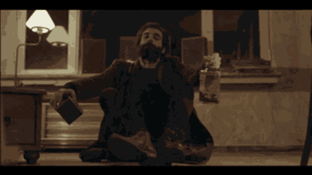 a man sitting on the floor holding a book