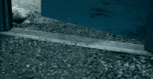 a blue door is open to a gravel ground