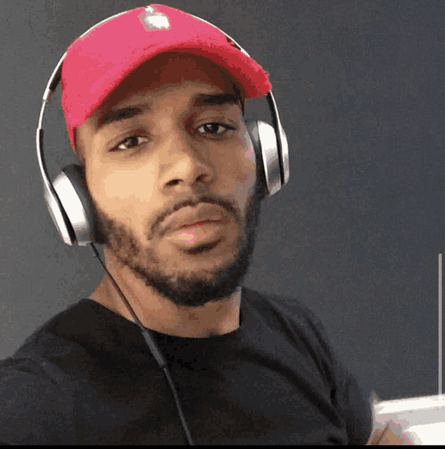 a man wearing headphones and a red baseball cap