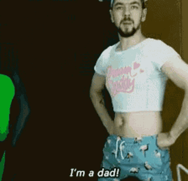 a man is wearing a crop top and shorts and saying i 'm a dad
