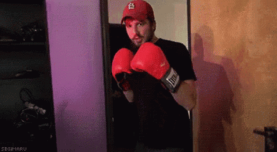 a man wearing red boxing gloves and a red hat with a ls logo on it